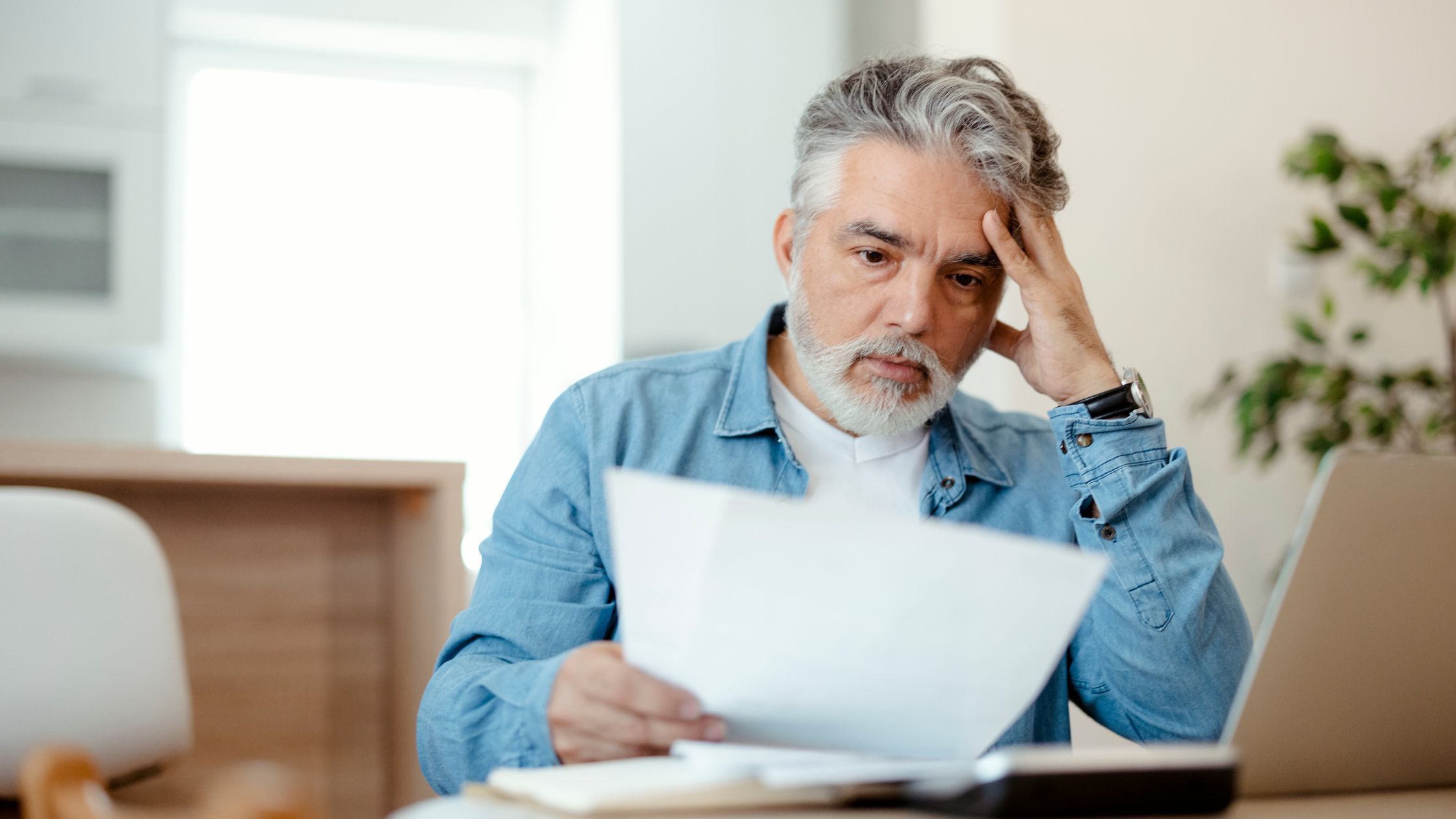 A person with a surprised expression looking at a piece of paper informing him of the new capital gains tax rate.